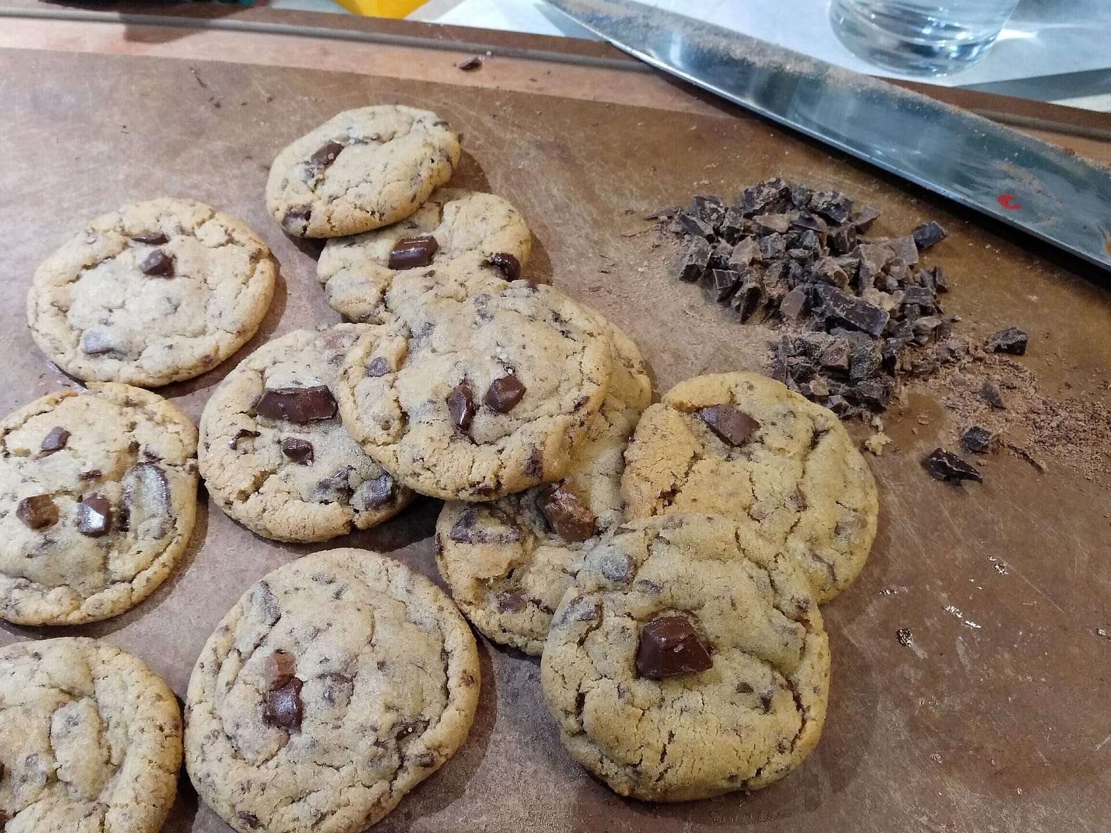 Chocolate chip cookies with melted chunks of dark chocolate spread on a baking sheet